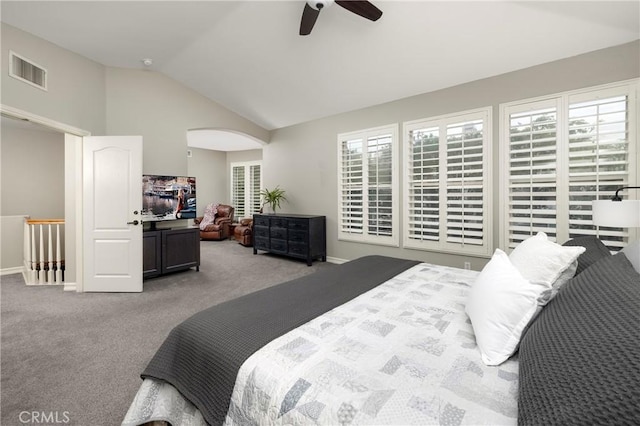 carpeted bedroom with vaulted ceiling, baseboards, ceiling fan, and arched walkways