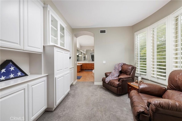 living room featuring light carpet and arched walkways