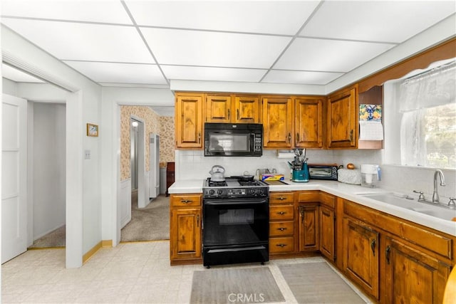10608 Beak Ave, South Gate, CA 90280 - kitchen with black appliances, light countertops, a sink, brown cabinets, and a paneled ceiling