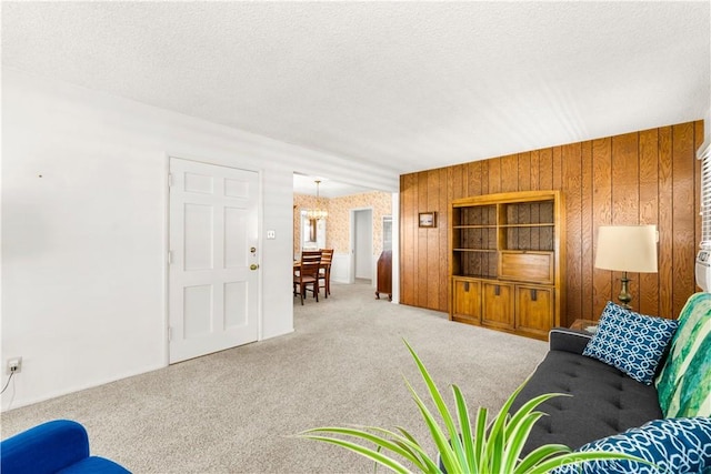 10608 Beak Ave, South Gate, CA 90280 - carpeted living room featuring a textured ceiling, wooden walls, and a chandelier