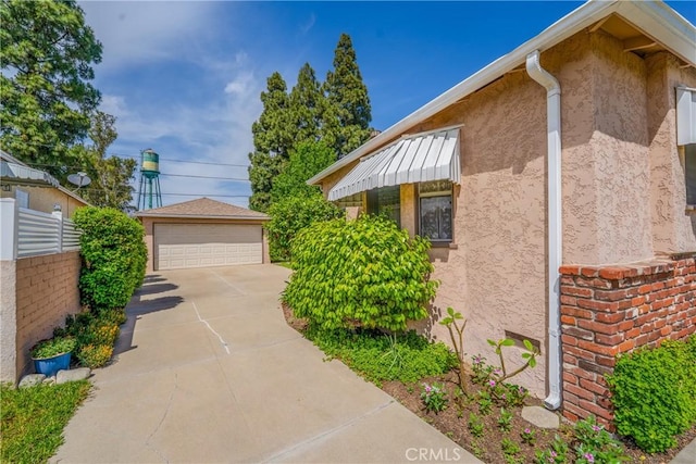 10608 Beak Ave, South Gate, CA 90280 - view of side of home with stucco siding, a detached garage, fence, and an outdoor structure