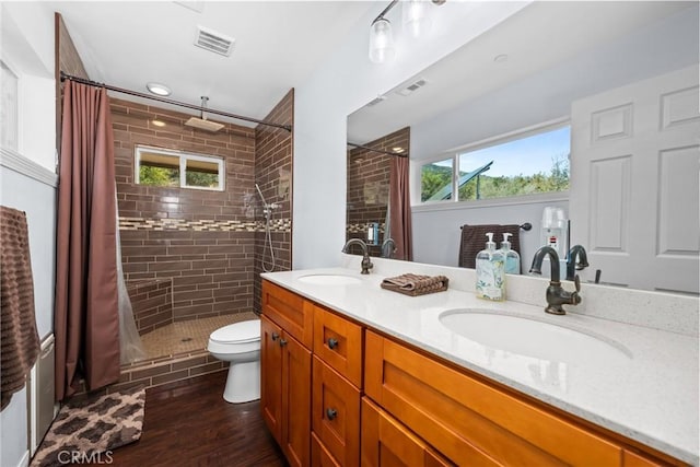 7525 Starlight Way, Julian, CA 92036 - bathroom with a tile shower, double vanity, wood finished floors, and toilet