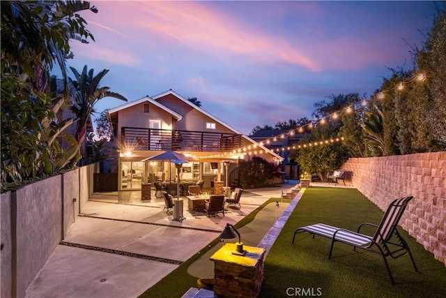 22602 Manalastas Dr, Lake Forest, CA 92630 - back of property at dusk featuring a balcony, a patio, and a fire pit