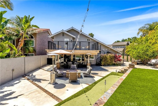 22602 Manalastas Dr, Lake Forest, CA 92630 - back of house with a putting area, a patio area, fence, and stucco siding