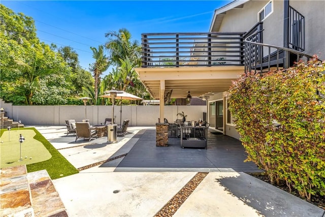 22602 Manalastas Dr, Lake Forest, CA 92630 - view of patio / terrace with an area to practice putting, a balcony, an outdoor fire pit, fence, and a ceiling fan