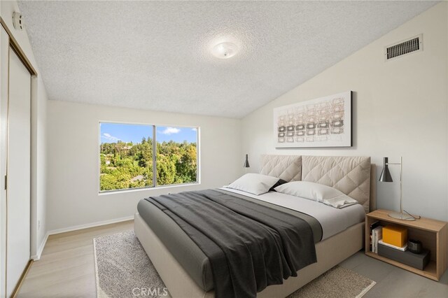 5932 Ellenview Ave, Woodland Hills, CA 91367 - bedroom with a textured ceiling, a closet, wood finished floors, vaulted ceiling, and baseboards