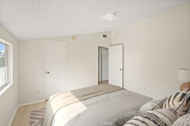 5932 Ellenview Ave, Woodland Hills, CA 91367 - bedroom with a textured ceiling, light wood-type flooring, baseboards, and lofted ceiling