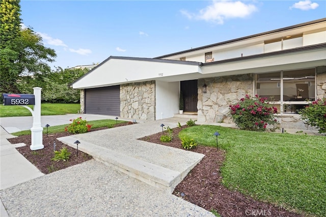 5932 Ellenview Ave, Woodland Hills, CA 91367 - view of front facade featuring stone siding, concrete driveway, a front yard, and an attached garage