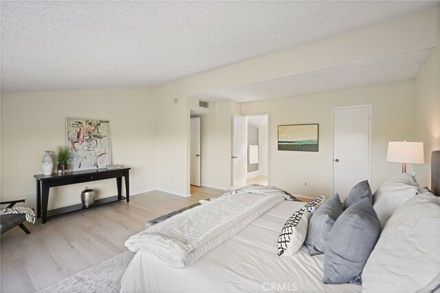 5932 Ellenview Ave, Woodland Hills, CA 91367 - bedroom with light wood finished floors, a textured ceiling, and baseboards