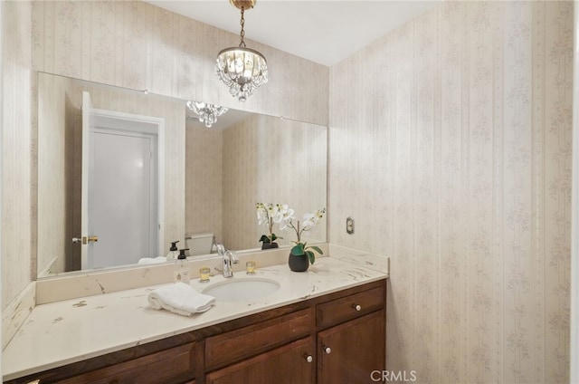 5932 Ellenview Ave, Woodland Hills, CA 91367 - bathroom with wallpapered walls, toilet, vanity, and a chandelier