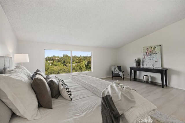 5932 Ellenview Ave, Woodland Hills, CA 91367 - bedroom featuring a textured ceiling, wood finished floors, baseboards, and vaulted ceiling