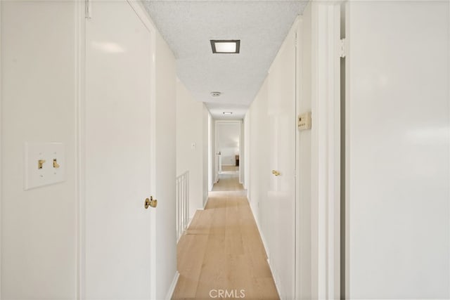 5932 Ellenview Ave, Woodland Hills, CA 91367 - hall with light wood-type flooring, a textured ceiling, and baseboards