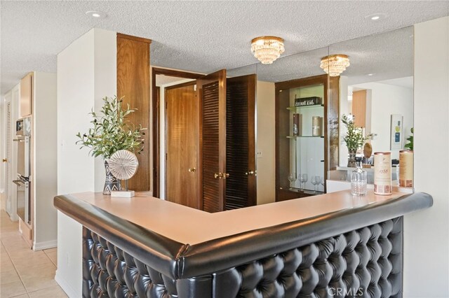 5932 Ellenview Ave, Woodland Hills, CA 91367 - indoor dry bar featuring light tile patterned flooring, a textured ceiling, and stainless steel double oven