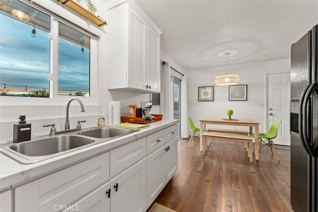 3872 Balsa Ave, Yucca Valley, CA 92284 - kitchen featuring a sink, black fridge with ice dispenser, light countertops, white cabinetry, and dark wood finished floors
