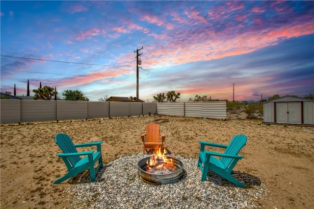 3872 Balsa Ave, Yucca Valley, CA 92284 - view of jungle gym featuring an outdoor fire pit, a storage unit, fence, and an outbuilding