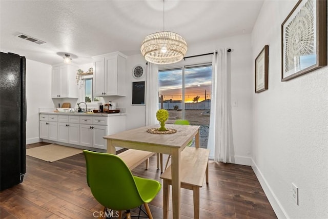 3872 Balsa Ave, Yucca Valley, CA 92284 - dining room featuring dark wood-style floors, baseboards, a chandelier, healthy amount of natural light, and a textured wall