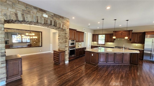 31820 Paseo Tarazona, San Juan Capistrano, CA 92675 - kitchen with appliances with stainless steel finishes, a sink, dark wood finished floors, decorative backsplash, and a center island with sink