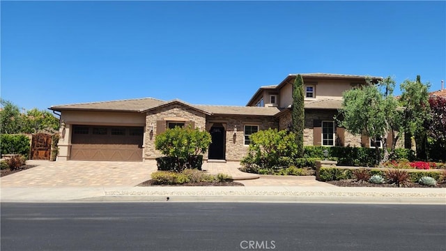 31820 Paseo Tarazona, San Juan Capistrano, CA 92675 - view of front of property with stone siding, an attached garage, stucco siding, and driveway