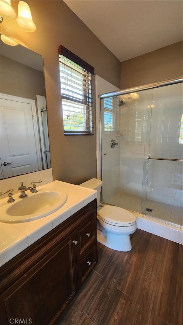 31820 Paseo Tarazona, San Juan Capistrano, CA 92675 - bathroom featuring wood finished floors, a stall shower, toilet, and vanity