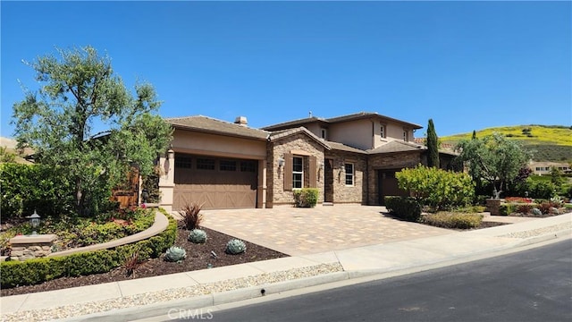 31820 Paseo Tarazona, San Juan Capistrano, CA 92675 - view of front of property with a garage, stucco siding, stone siding, and driveway