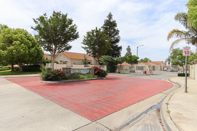 10260 Santa Rosa Ct, Rancho Cucamonga, CA 91730 - view of decorative road with curbs, a gate, sidewalks, street lights, and traffic signs