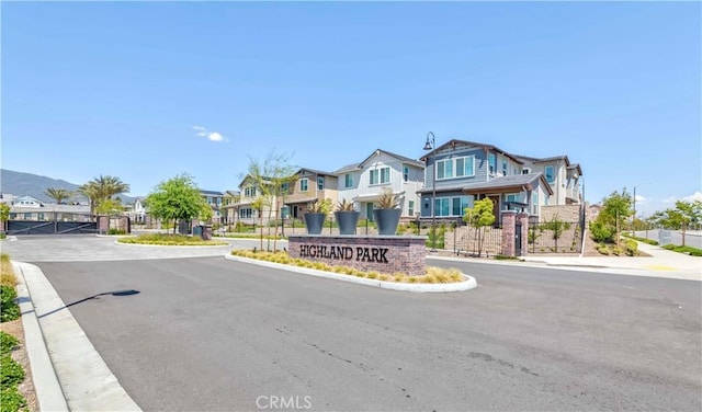 14991 Cavetto Ln, Fontana, CA 92336 - view of asphalt road with a residential view, a gate, street lights, curbs, and sidewalks