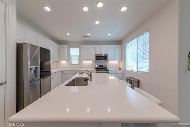 14991 Cavetto Ln, Fontana, CA 92336 - kitchen featuring stainless steel appliances, a sink, white cabinetry, a large island with sink, and recessed lighting