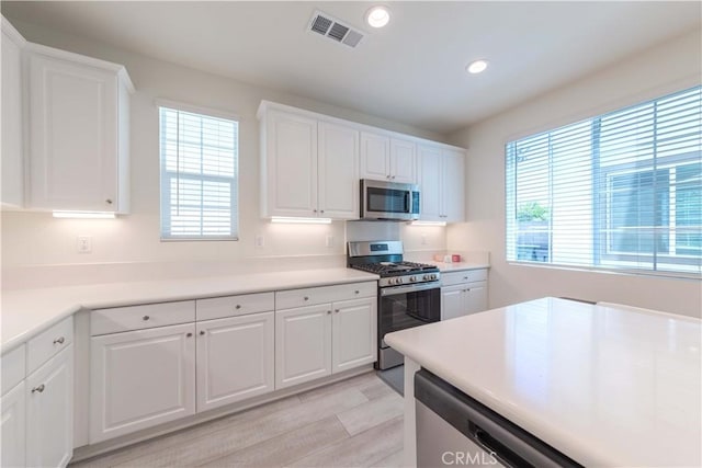 14991 Cavetto Ln, Fontana, CA 92336 - kitchen with stainless steel appliances, recessed lighting, light wood-style flooring, white cabinetry, and light countertops