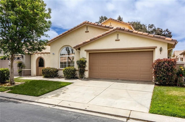 4919 Oakhurst Ave, Banning, CA 92220 - mediterranean / spanish-style house featuring an attached garage, concrete driveway, stucco siding, and a tiled roof