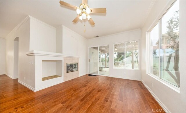 4919 Oakhurst Ave, Banning, CA 92220 - unfurnished living room with wood finished floors, arched walkways, crown molding, ceiling fan, and baseboards