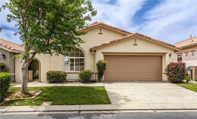 4919 Oakhurst Ave, Banning, CA 92220 - mediterranean / spanish home featuring an attached garage, driveway, stucco siding, and a tiled roof