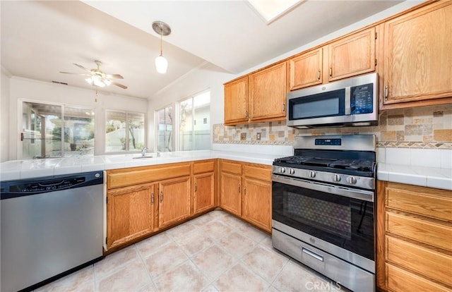 4919 Oakhurst Ave, Banning, CA 92220 - kitchen featuring stainless steel appliances, tasteful backsplash, ornamental molding, ceiling fan, and tile counters