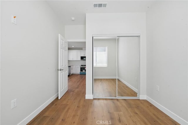 8142 Vantage Ave, North Hollywood, CA 91605 - unfurnished bedroom with light wood finished floors, a closet, and baseboards
