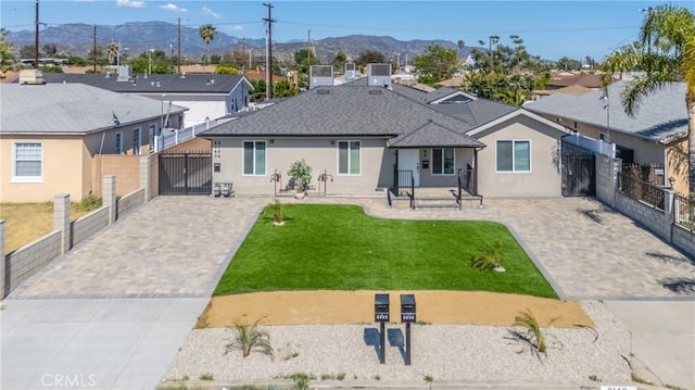 8142 Vantage Ave, North Hollywood, CA 91605 - back of house with a mountain view, a gate, stucco siding, decorative driveway, and roof with shingles