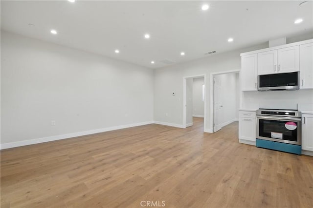 8142 Vantage Ave, North Hollywood, CA 91605 - kitchen with stainless steel microwave, stove, baseboards, white cabinets, and open floor plan