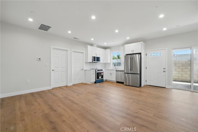 8142 Vantage Ave, North Hollywood, CA 91605 - kitchen featuring appliances with stainless steel finishes, recessed lighting, white cabinetry, light wood-type flooring, and light countertops
