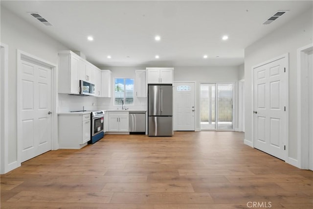8142 Vantage Ave, North Hollywood, CA 91605 - kitchen with stainless steel appliances, white cabinetry, light wood-style floors, and recessed lighting