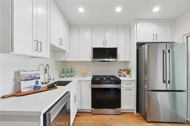 8142 Vantage Ave, North Hollywood, CA 91605 - kitchen with appliances with stainless steel finishes, a sink, white cabinets, light countertops, and light wood-style floors