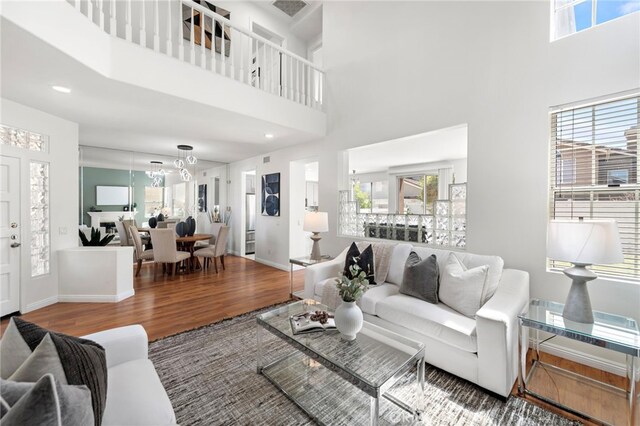 15283 Rousseau Ln, La Mirada, CA 90638 - living room with wood finished floors, a chandelier, a towering ceiling, and baseboards