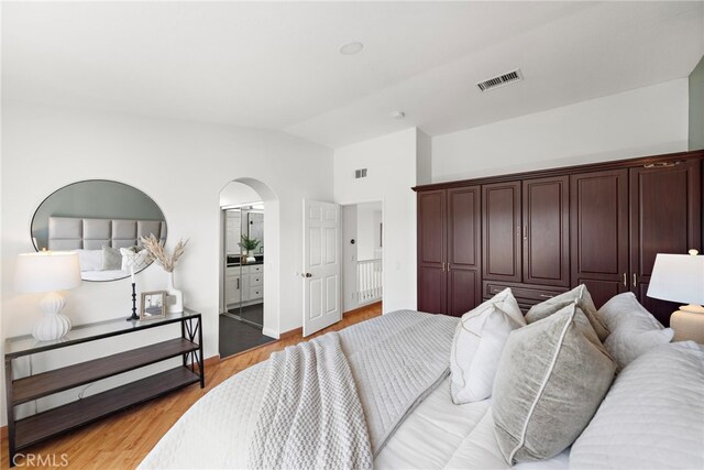 15283 Rousseau Ln, La Mirada, CA 90638 - bedroom featuring vaulted ceiling, arched walkways, light wood-style flooring, and baseboards