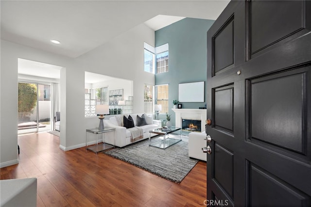 15283 Rousseau Ln, La Mirada, CA 90638 - living area featuring dark wood-style floors, a lit fireplace, recessed lighting, and a high ceiling