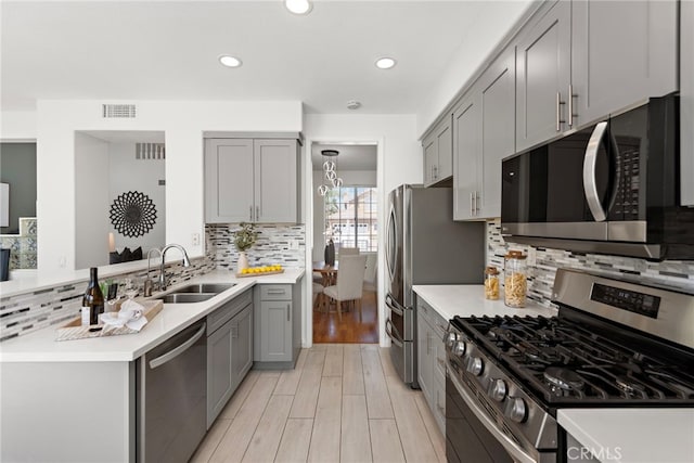 15283 Rousseau Ln, La Mirada, CA 90638 - kitchen with stainless steel appliances, a sink, gray cabinets, light wood-type flooring, and recessed lighting