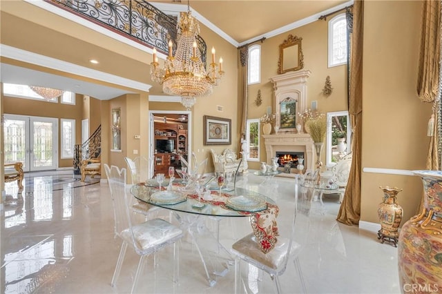 dining room with baseboards, plenty of natural light, a towering ceiling, a lit fireplace, and ornamental molding