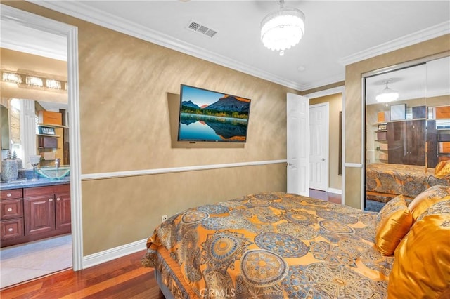 bedroom featuring wood finished floors, baseboards, and crown molding