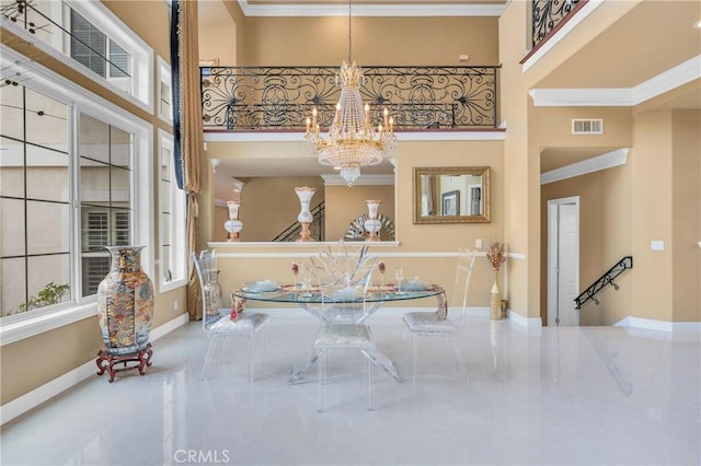 dining room featuring a chandelier, a high ceiling, ornamental molding, and baseboards