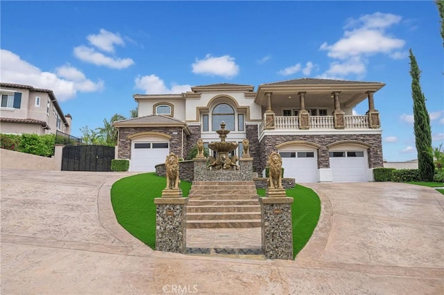 mediterranean / spanish home with driveway, a balcony, and stone siding