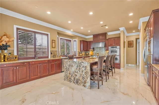 kitchen with wall chimney exhaust hood, light marble finish flooring, tasteful backsplash, recessed lighting, and crown molding