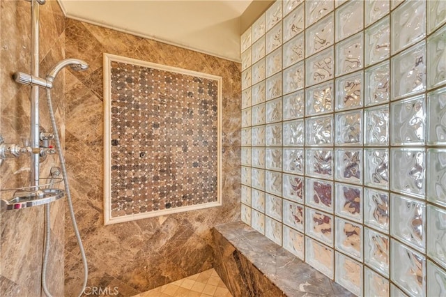full bathroom with a tile shower and tile walls