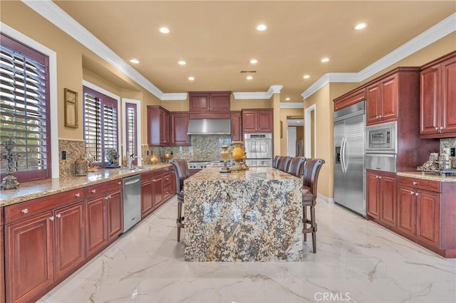 kitchen with built in appliances, a warming drawer, wall chimney exhaust hood, a kitchen island, and decorative backsplash