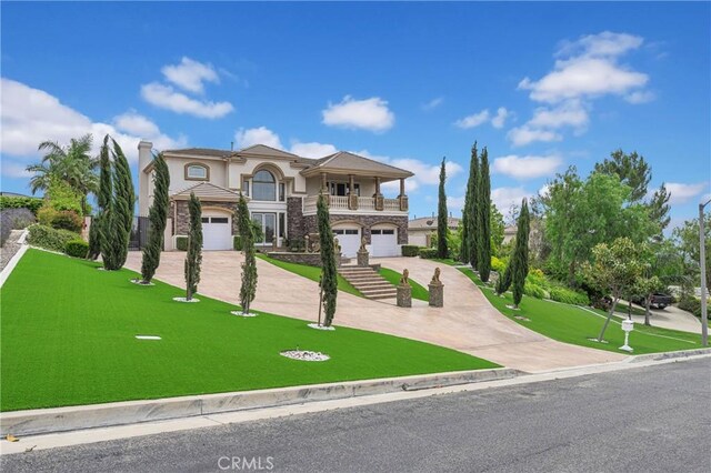view of front of home with a garage, concrete driveway, a balcony, stucco siding, and a front lawn